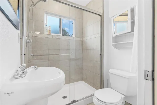 a white toilet sitting next to a white tub