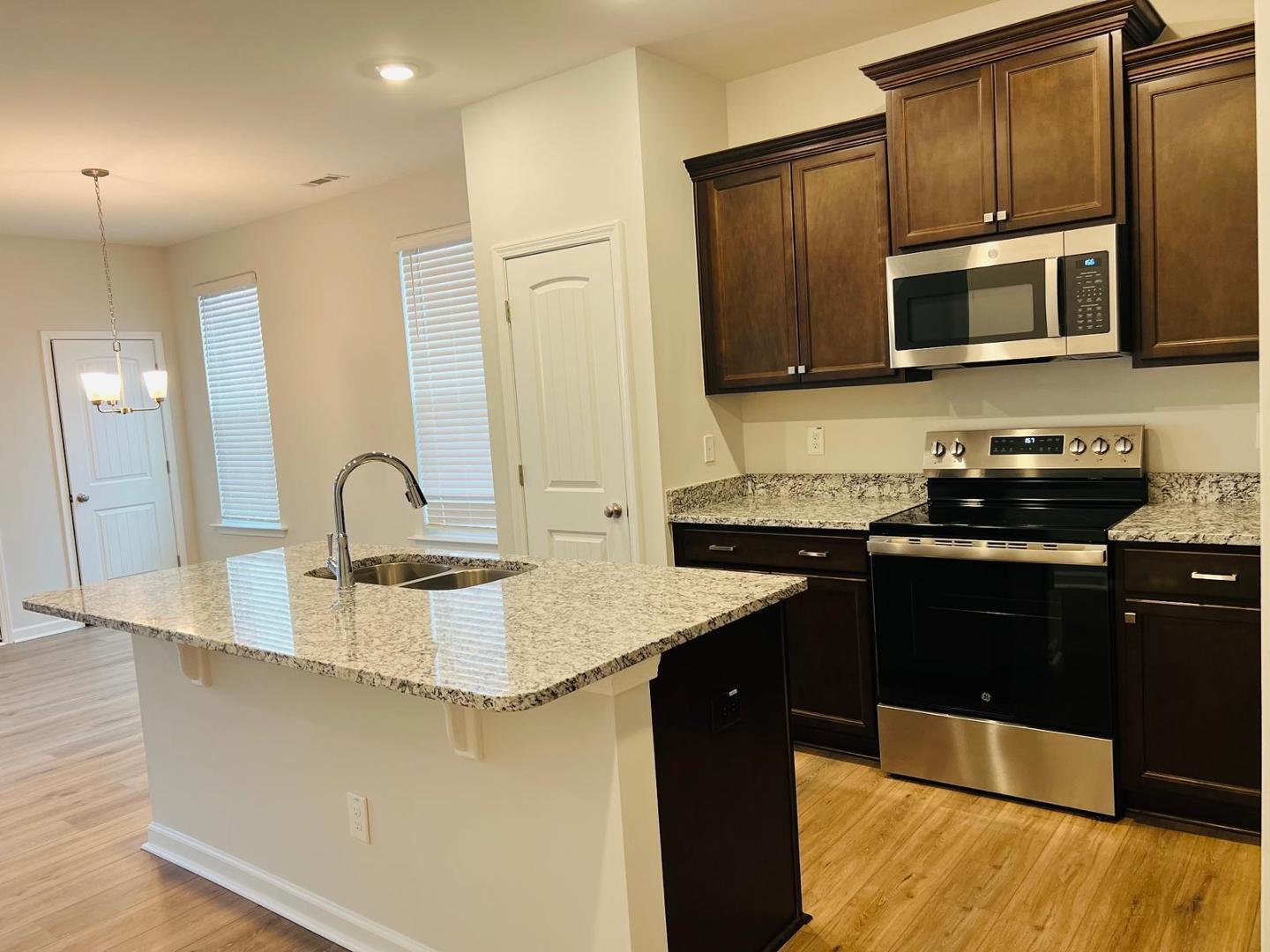 183 Chesapeake Commons Street Garner, NC 27529 - Photo 7 of 26 a kitchen with stainless steel appliances granite countertop a sink stove and microwave