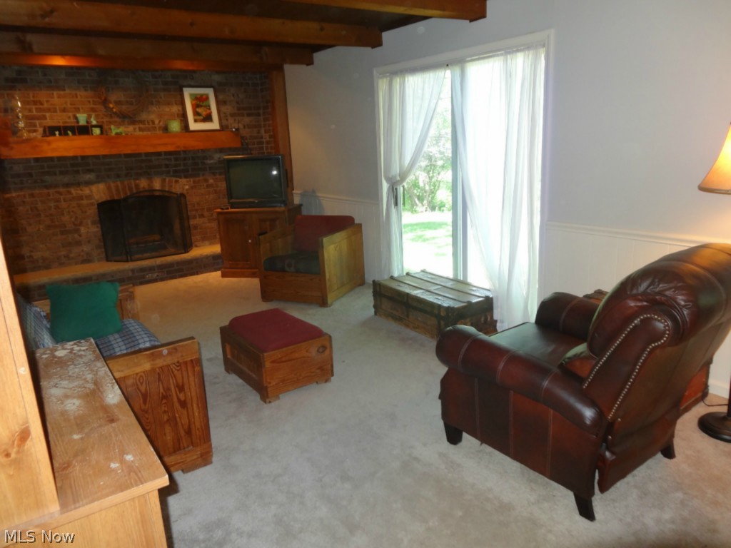 4555 Beat Road Litchfield, OH 44253 - Photo 7 of 20 Family Room features a brick wall and fireplace. Beamed ceiling. Sliding door.