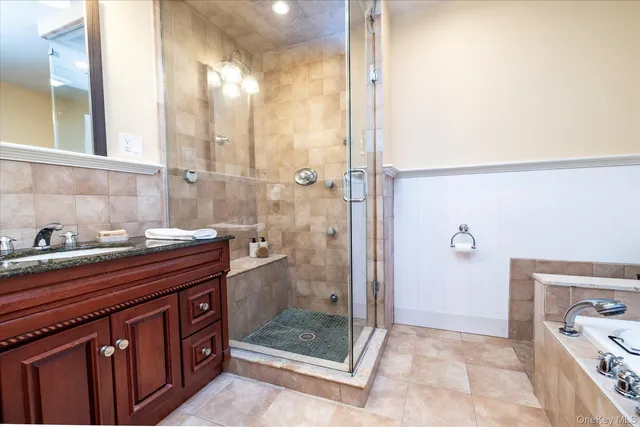 a bathroom with a granite countertop sink a mirror and a shower
