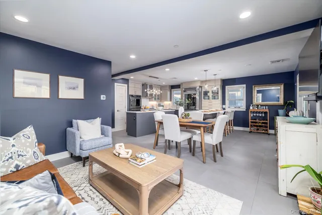 a living room with furniture a table and kitchen view