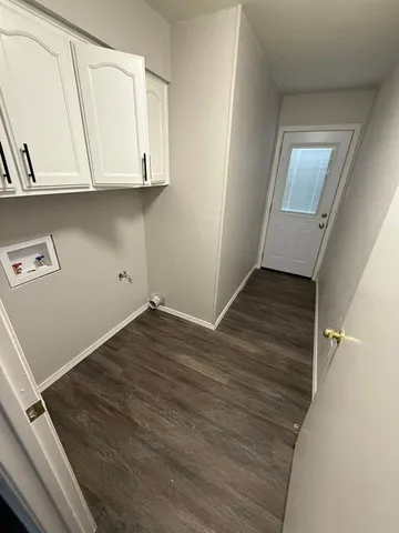 a room with wooden floor and cabinets