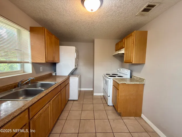 a kitchen that has a sink and a stove in it