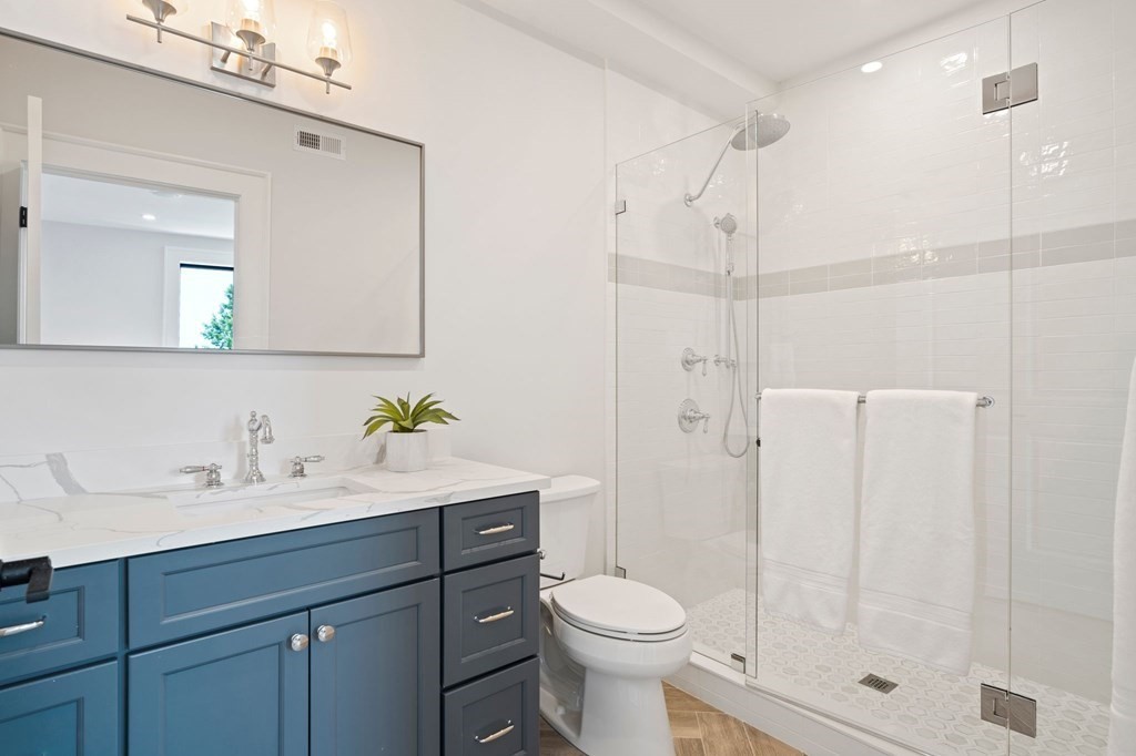 9 Glover Court, Unit 6 Boston, MA 02127 - Photo 23 of 34 a bathroom with a sink toilet a mirror and shower