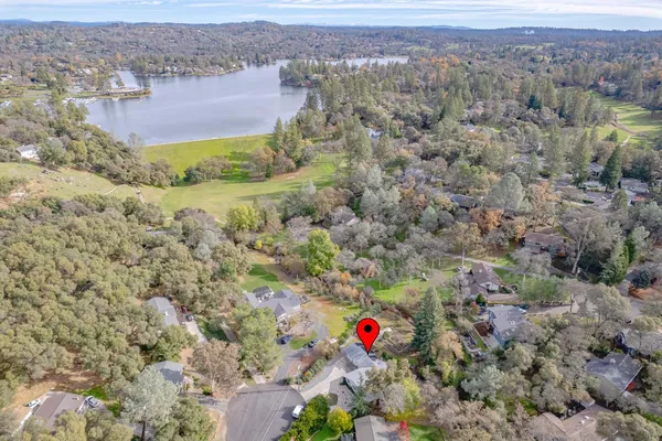an aerial view of residential houses with outdoor space and trees