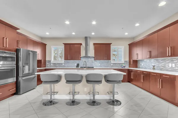 a kitchen with stainless steel appliances granite countertop a table chairs sink and cabinets