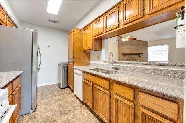 a kitchen with stainless steel appliances granite countertop a sink and a refrigerator