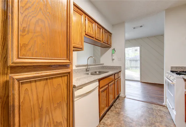 a kitchen with stainless steel appliances granite countertop a sink and a stove with wooden floor