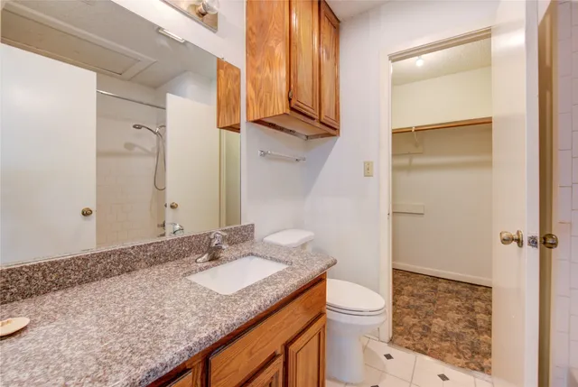 a bathroom with a granite countertop sink toilet and shower