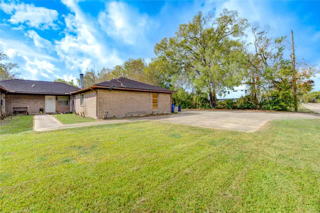 a front view of a house with yard and tree