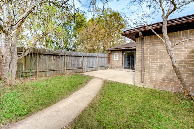 a view of a house with a yard and wooden fence