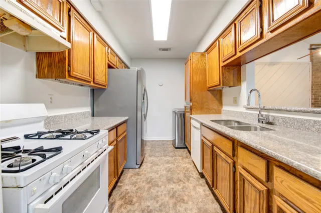 a kitchen with stainless steel appliances granite countertop a sink stove and refrigerator