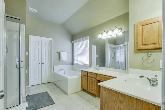 a spacious bathroom with a tub sink and mirror