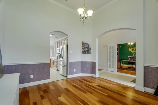 a bedroom with a large bed and a chandelier