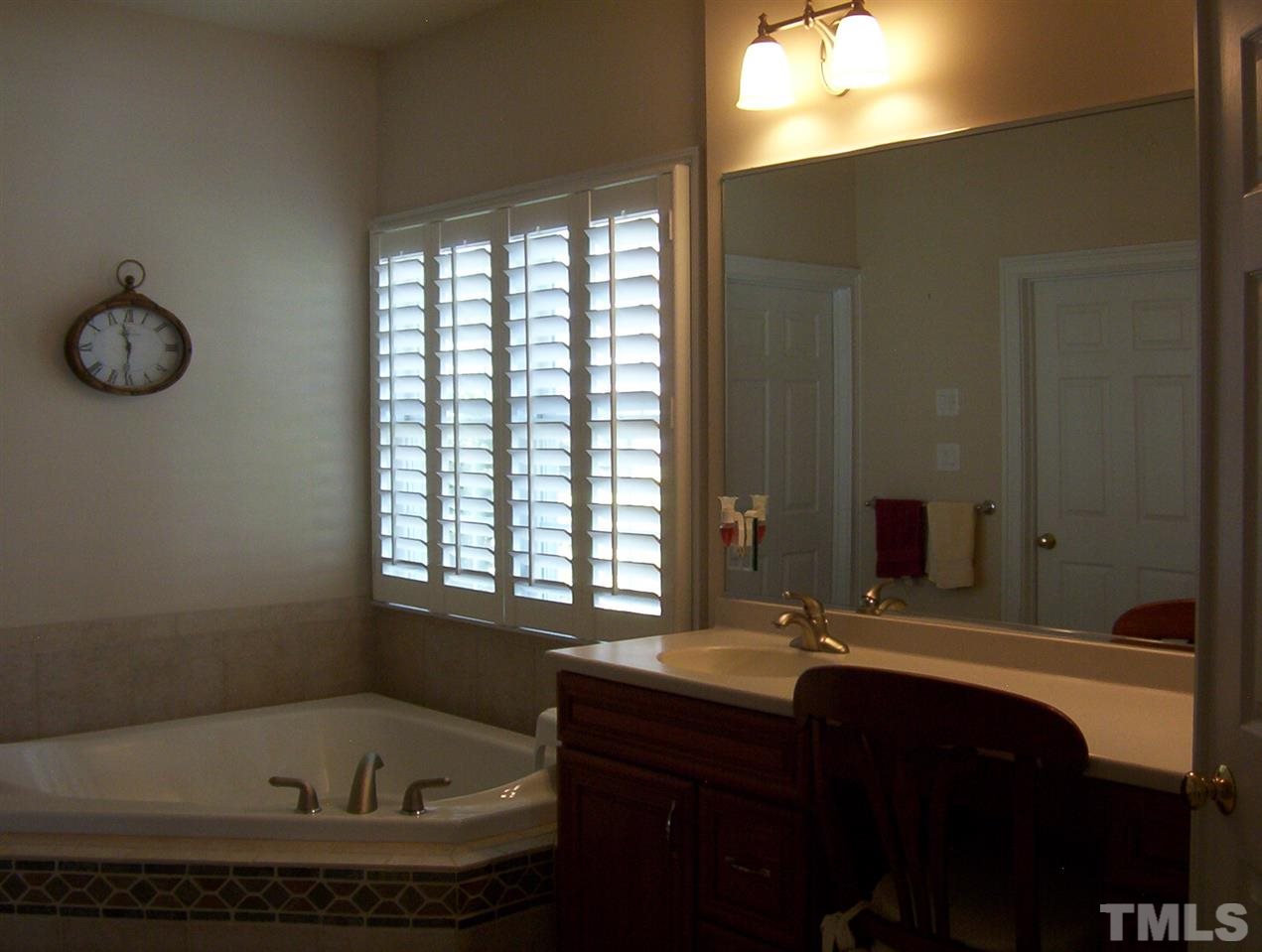 10652 Tarton Fields Circle Raleigh, NC 27617 - Photo 16 of 25 a bathroom with a tub sink and mirror
