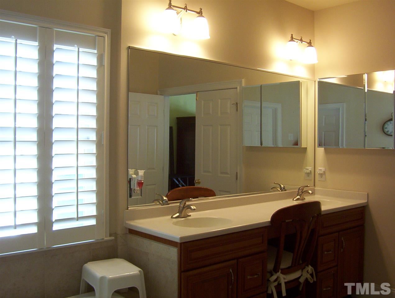 10652 Tarton Fields Circle Raleigh, NC 27617 - Photo 17 of 25 a bathroom with a double vanity sink a mirror and a bathtub