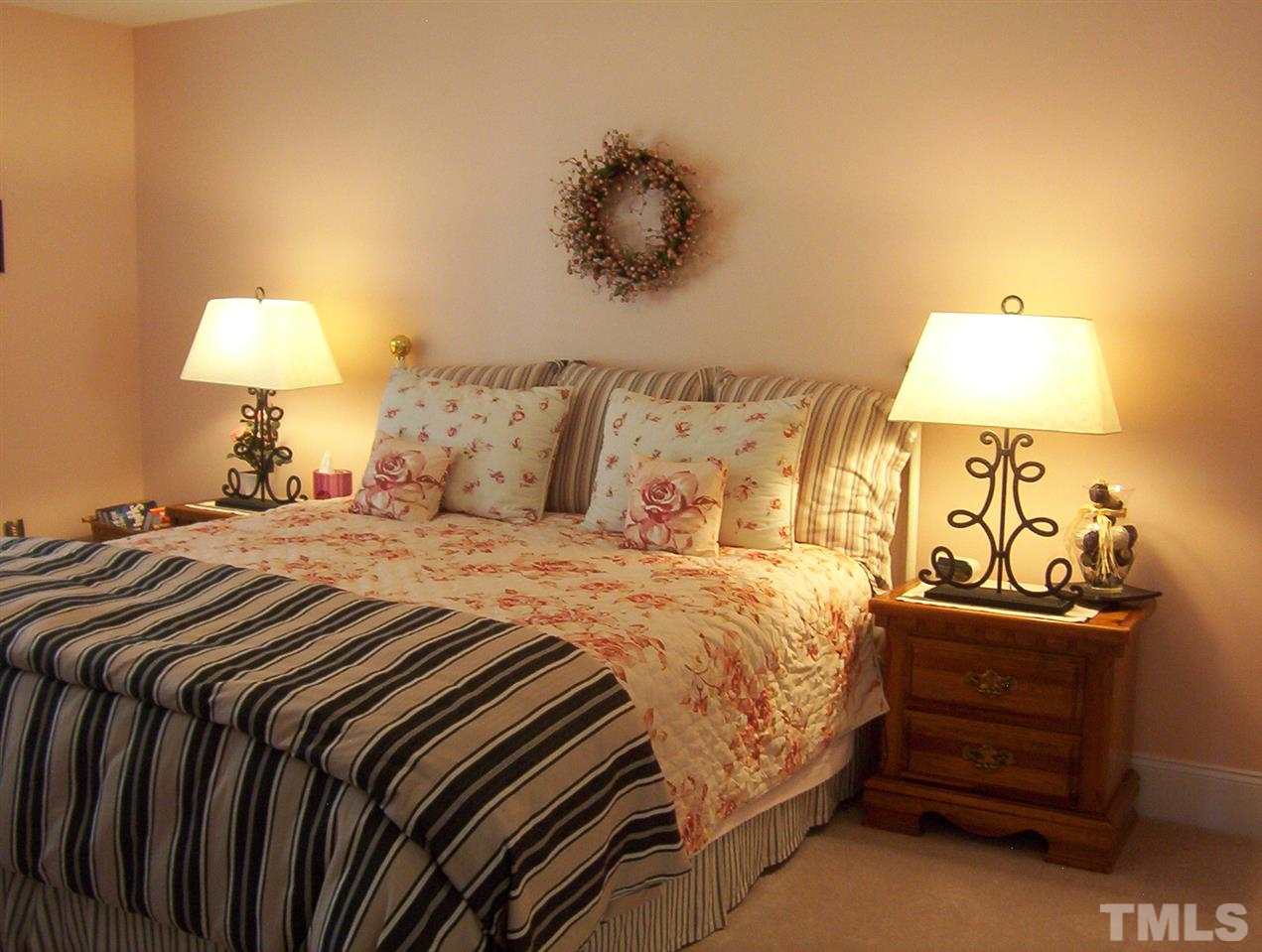 10652 Tarton Fields Circle Raleigh, NC 27617 - Photo 21 of 25 a bedroom with a bed and a lamp