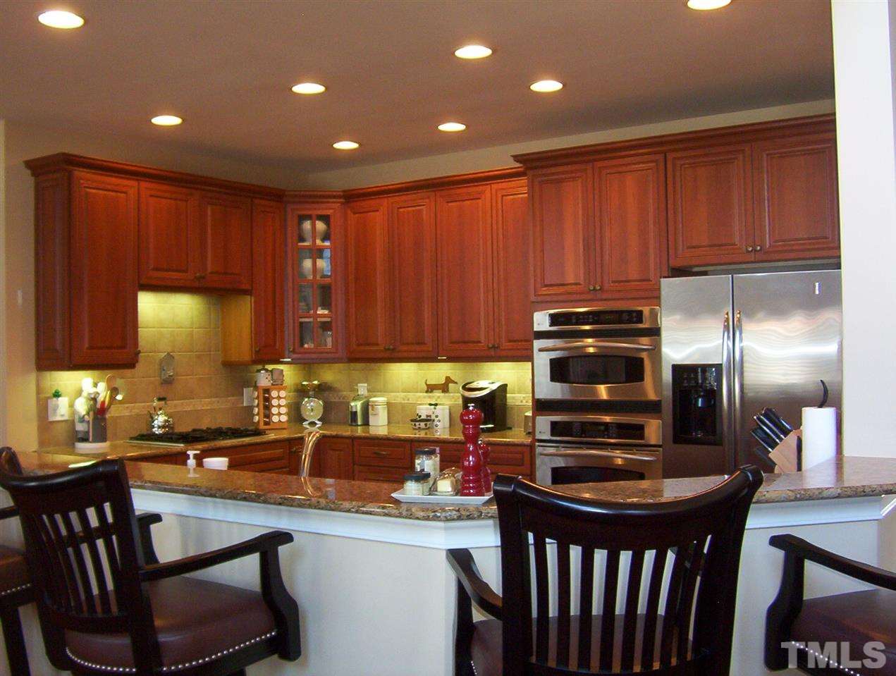 10652 Tarton Fields Circle Raleigh, NC 27617 - Photo 6 of 25 a kitchen with a stove a sink and a refrigerator
