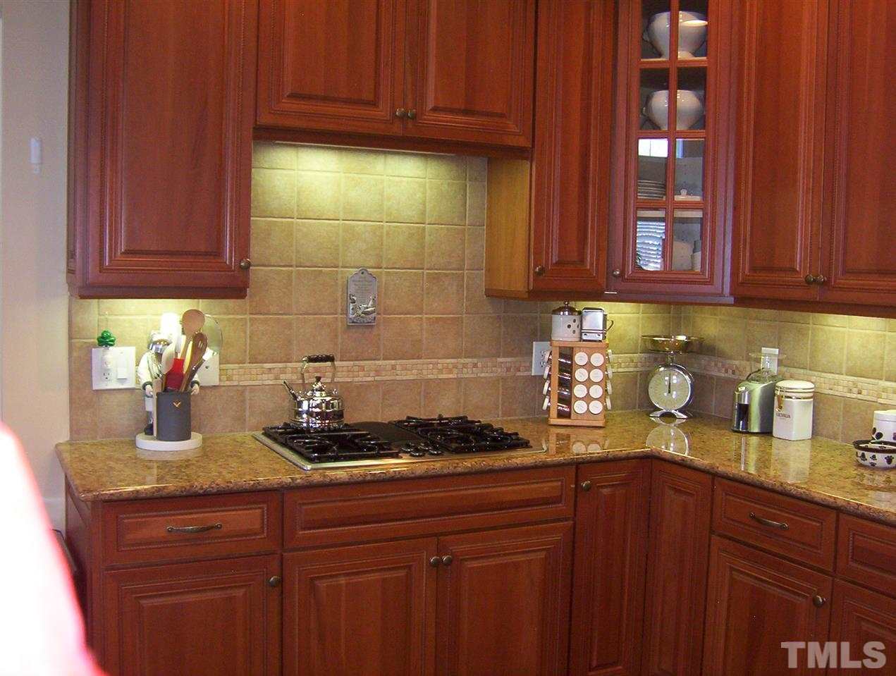 10652 Tarton Fields Circle Raleigh, NC 27617 - Photo 8 of 25 a kitchen with granite countertop cabinets and wooden floor