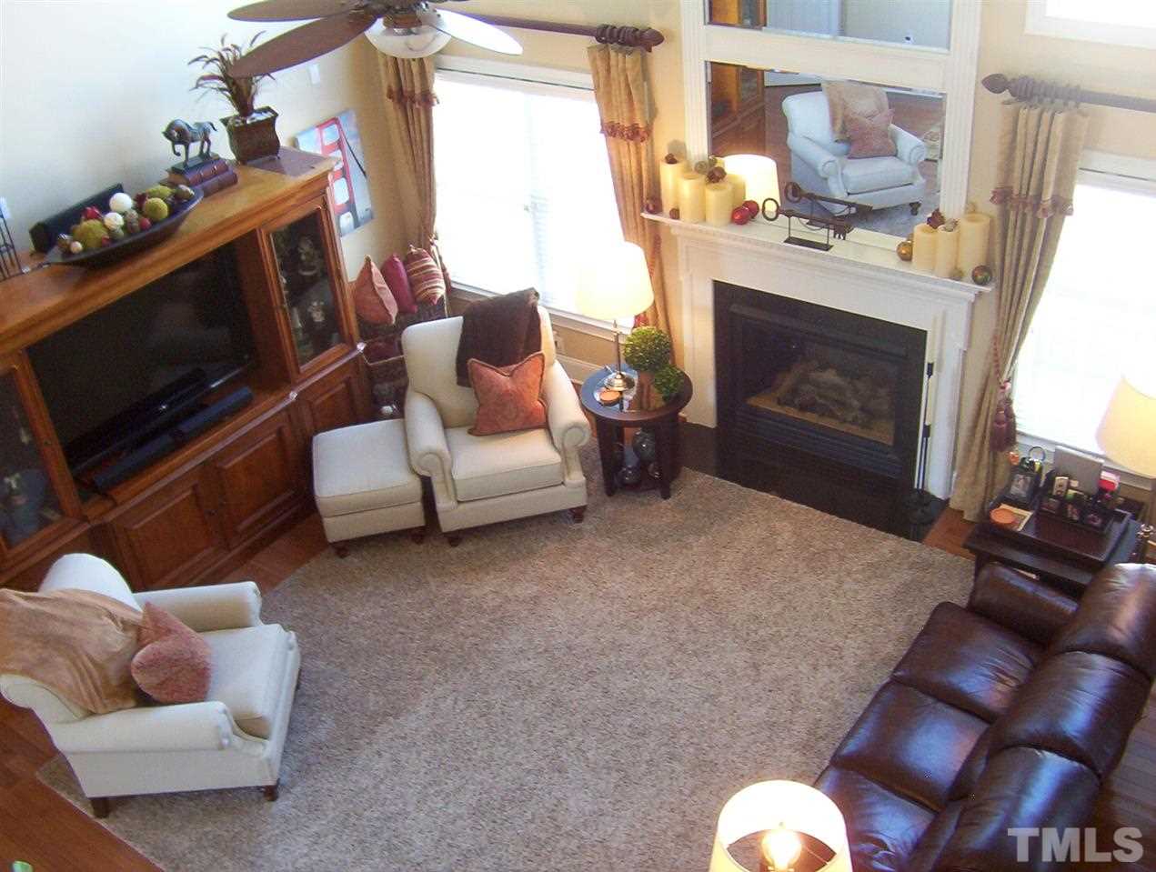 10652 Tarton Fields Circle Raleigh, NC 27617 - Photo 10 of 25 a living room with furniture a fireplace and a flat screen tv