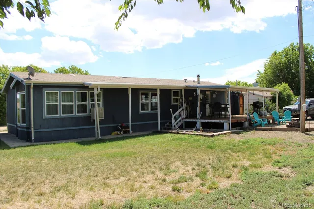 a view of a house with a yard and sitting area