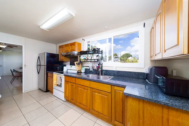 a kitchen with stainless steel appliances granite countertop a sink counter space and a window