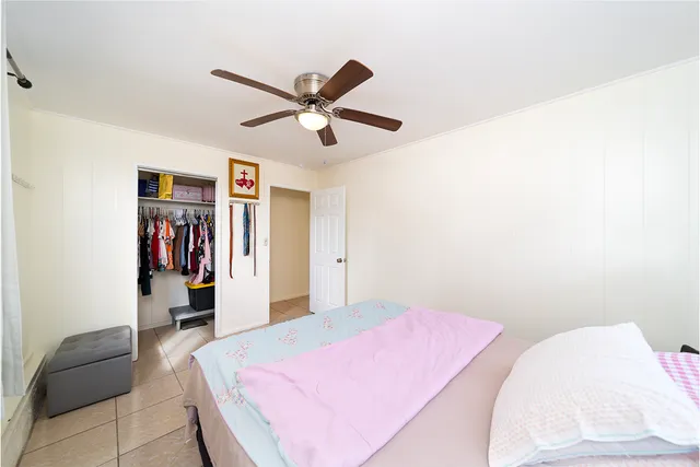 a bedroom with a bed and a ceiling fan