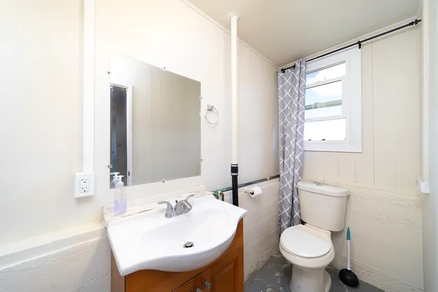 a bathroom with a sink toilet and mirror