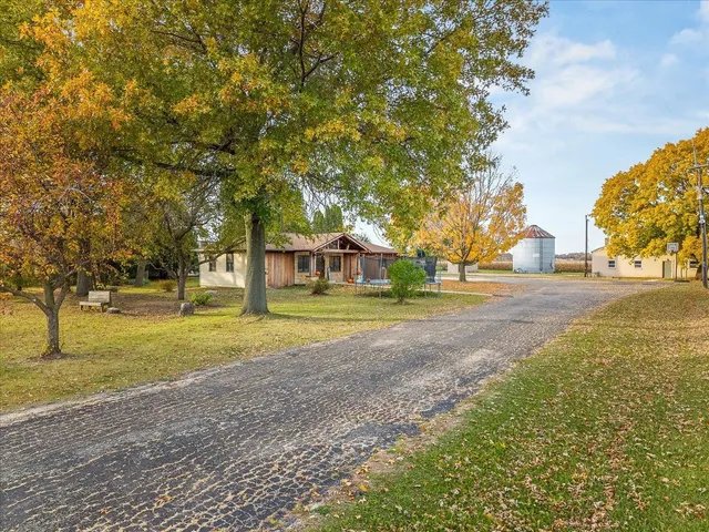 a view of a house with a big yard and large trees