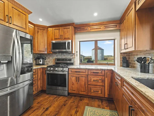 a kitchen with stainless steel appliances granite countertop a stove a sink and a refrigerator