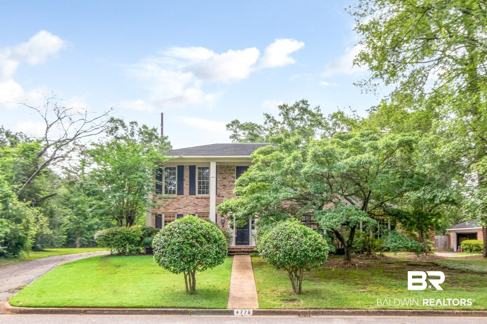4776 Falls Church Road Mobile, AL 36608 - Photo 42 of 45 Brick facade home with a columned portico, black shutters, and a dark front door