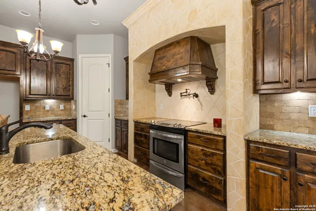 a kitchen with stainless steel appliances granite countertop a stove and a refrigerator