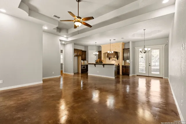 a view of an empty room and kitchen view