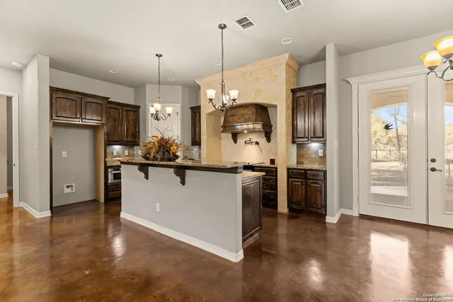 a kitchen with stainless steel appliances granite countertop a sink a stove and a wooden floor