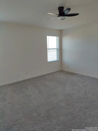 an empty room with a window and a ceiling fan