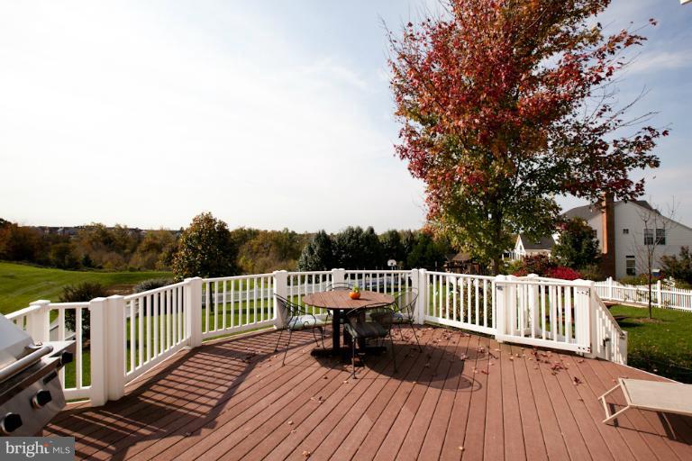 a balcony with wooden floor table and chairs