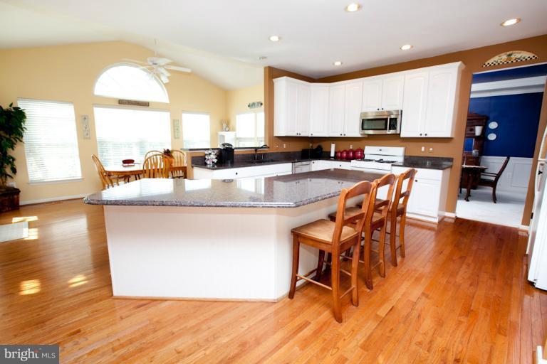 14410 Autumn Crest Road Boyds, MD 20841 - Photo 12 of 25 a kitchen with stainless steel appliances granite countertop a stove top oven a sink a dining table and chairs