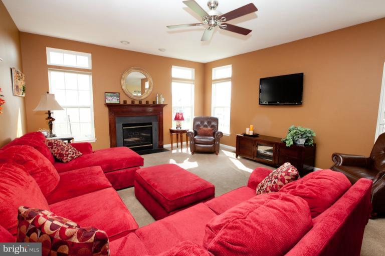 14410 Autumn Crest Road Boyds, MD 20841 - Photo 13 of 25 a living room with furniture a fireplace and a flat screen tv