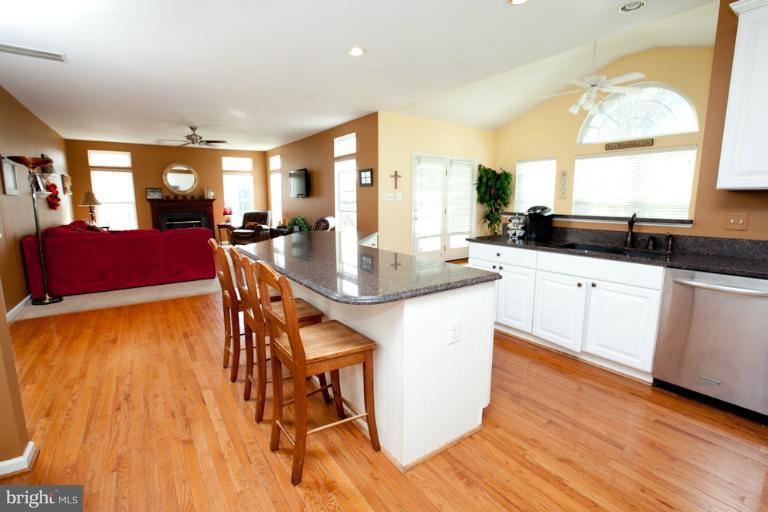 14410 Autumn Crest Road Boyds, MD 20841 - Photo 23 of 25 a kitchen with granite countertop a stove a sink a dining table and chairs with wooden floor