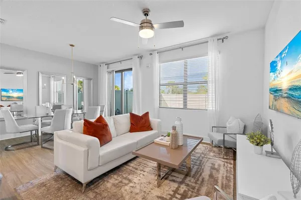 a living room with furniture a flat screen tv and a window