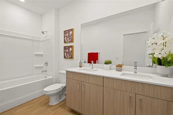 a bathroom with a toilet sink a bathtub and a vanity