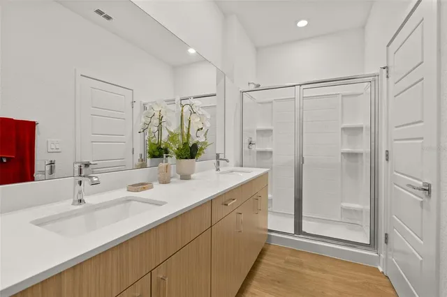 a bathroom with a double vanity sink mirror double and shower