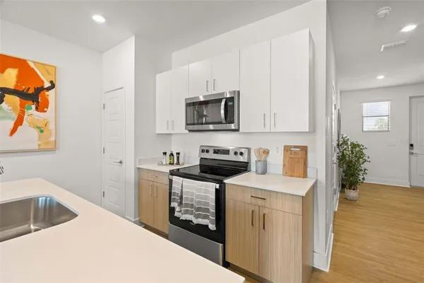 a kitchen with stainless steel appliances granite countertop a stove a sink and a microwave