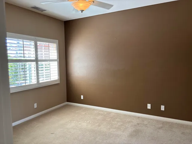 an empty room with a fireplace and chandelier