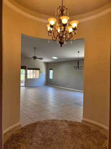 an empty room with windows and ceiling fan