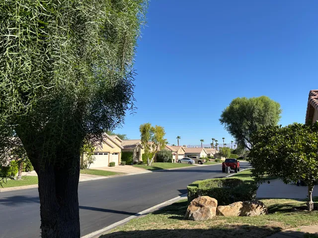 a view of a house with a tree and wooden fence