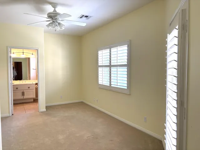 a view of an empty room with window and cabinet