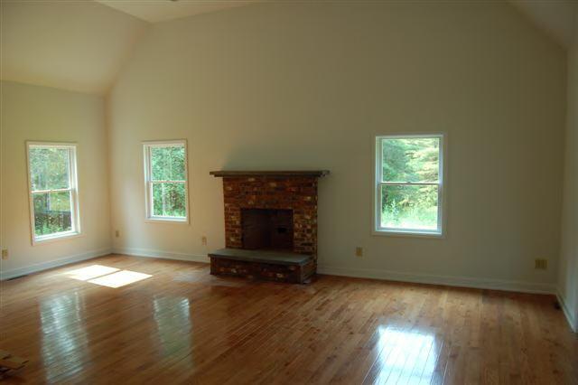 746 Foley Road Sheffield, MA 01257 - Photo 3 of 6 an empty room with a fireplace and windows