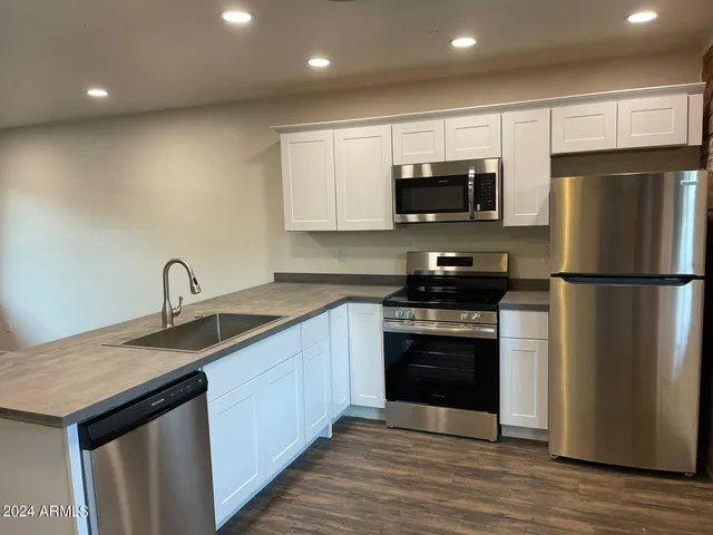 a kitchen with stainless steel appliances granite countertop a stove a sink and a refrigerator