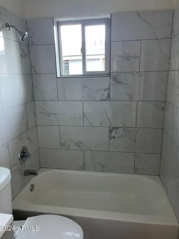 a bathroom with a toilet and bathtub